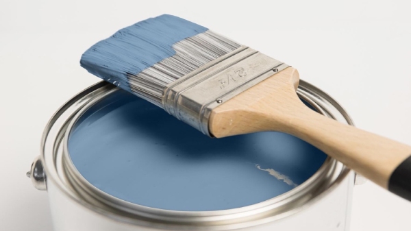 Pot of blue paint with a paint brush